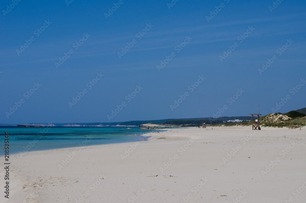 Landscape photography of one of the most touristic and largest beaches in Menorca. A white cloak wrapped in blue.