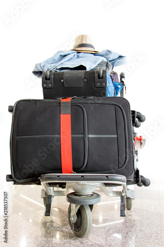 A pile of luggage on a cart at the airport. Suitcase loaded on the trolley, stand in the hall.