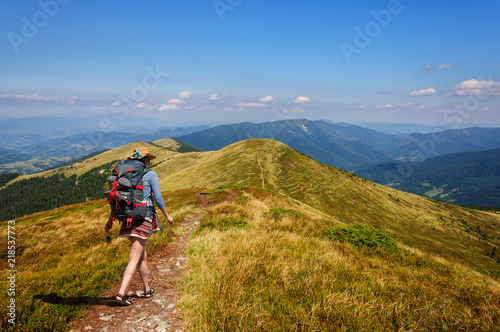 girl with a big backpack rises to the mountains. Ukraine