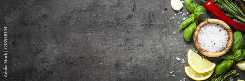 Selection of spices and herbs  on dark stone table.  © nadianb