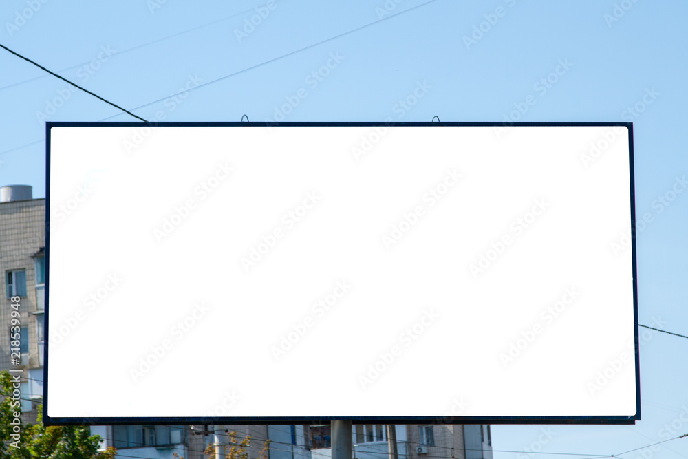 White billboard on the background of a residential high-rise building. Outdoor advertising in a residential area. Empty white canvas bigboard with space for text. Big billboard in the city landscape. White billboard on the background of a residential high-rise building. Outdoor advertising in a residential area. Empty white canvas bigboard with space for text. Big billboard in the city landscape.