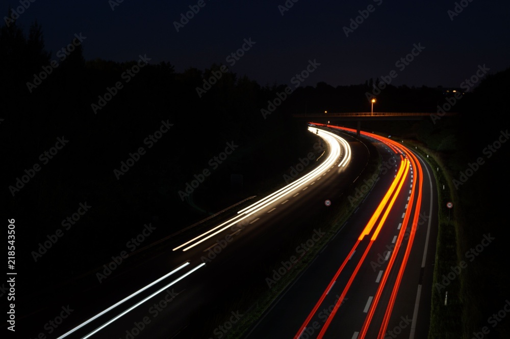 Automobile light trails, night traffic on the highway, city landscape. Picture taken with long exposure shooting