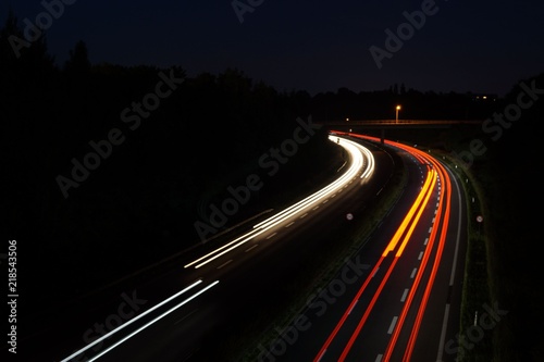 Automobile light trails, night traffic on the highway, city landscape. Picture taken with long exposure shooting