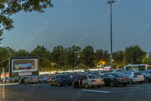 city parking with an inflatable screen of a summer cinema, waiting for a movie