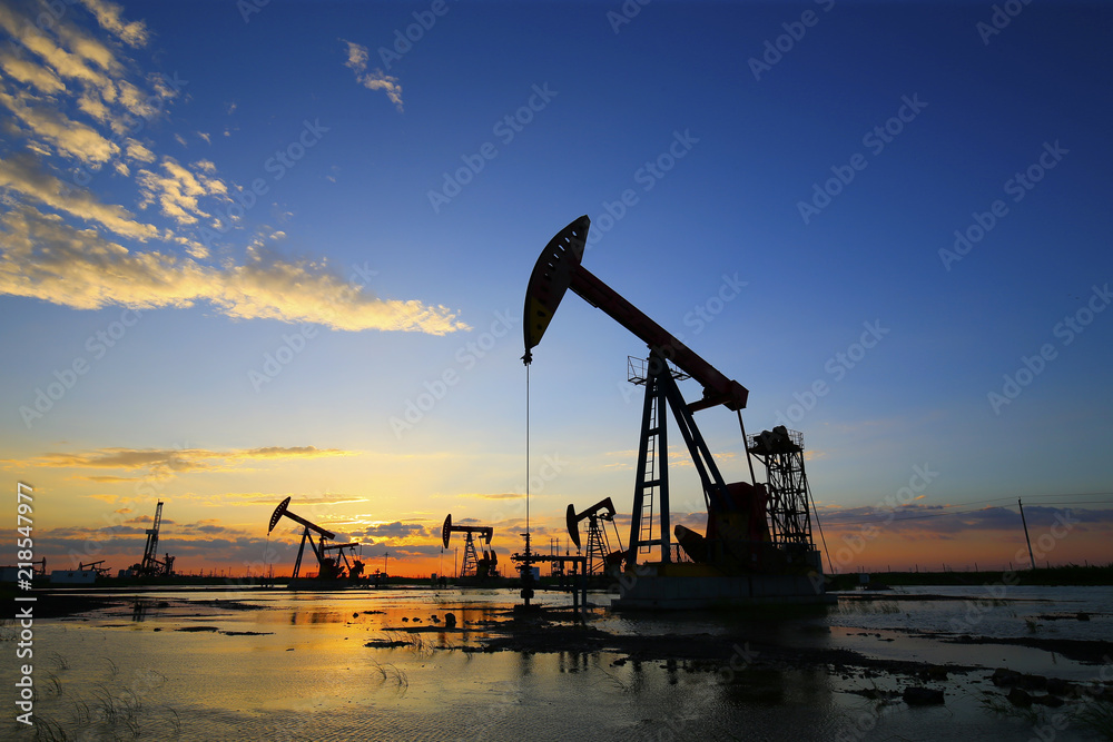 The pumping unit is working in the setting sun The pumping unit is working in the setting sun