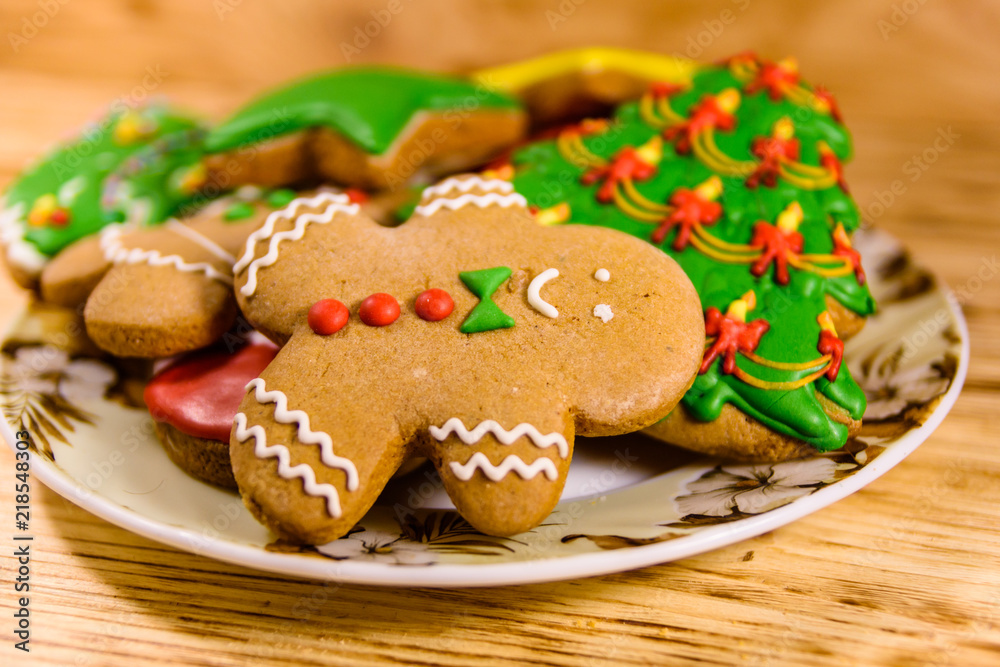 Plate with different christmas gingerbread cookies on wooden table