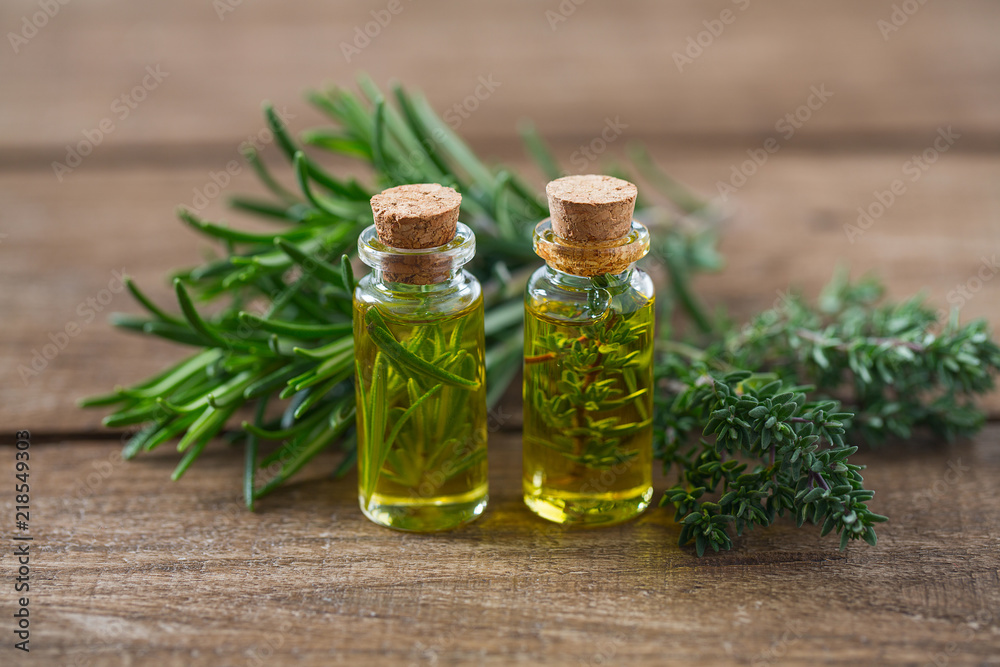 olive oil with herbs on wooden surface olive oil with herbs on wooden surface