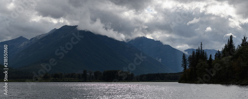 Sun rays peak through dramatic clouds over St Mary Lake in Kimberley  Canada