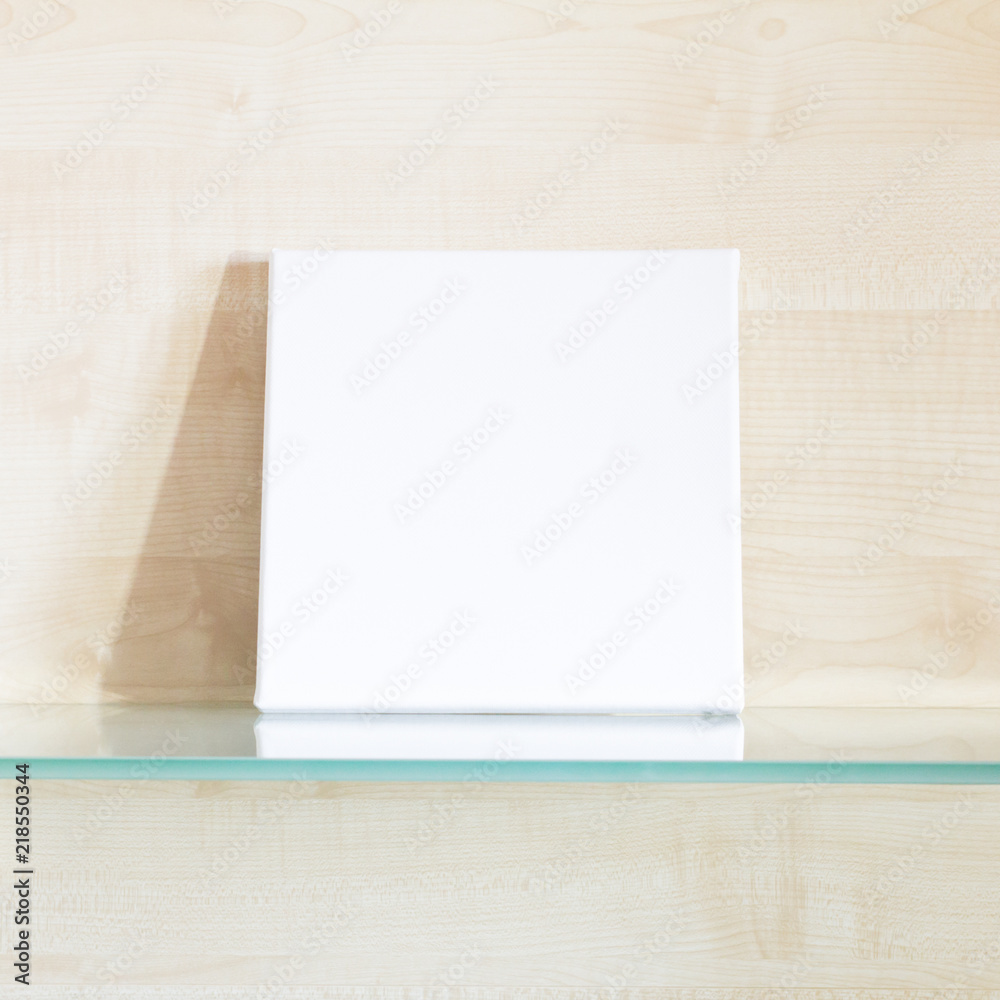 Mock-up poster. Square white canvas, light wooden wall on background. Mock-up poster. Square white canvas, light wooden wall on background.