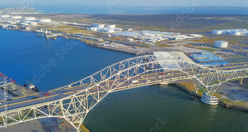 Fotografie Panorama aerial view of Corpus Christi Harbor Bridge with row of oil tanks and wind turbines farm in distance