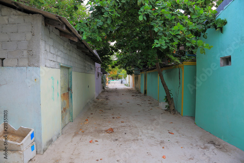 Maldives, Dhangethi Island. One of the streets on island. Poor society, old houses and sand roads. photo