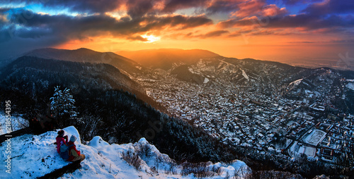 A panoramic view of the city Brasov at sunset above the Mount Tampa in the winter time photo