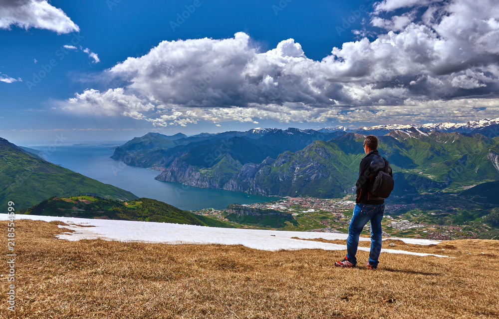 Monte Stivo,Lago di Garda ,Italy - 14 May 2014: A young man admiring the Garda lake at the top of Mount Stivo, Popular destinations for travel in Europe. Italian Dolomites-panoramic views