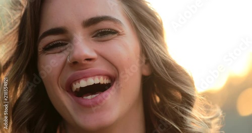 Hispanic latina girl smiling and laughing to camera. Portrait of young woman looking to directly to camera happy with authentic laugh