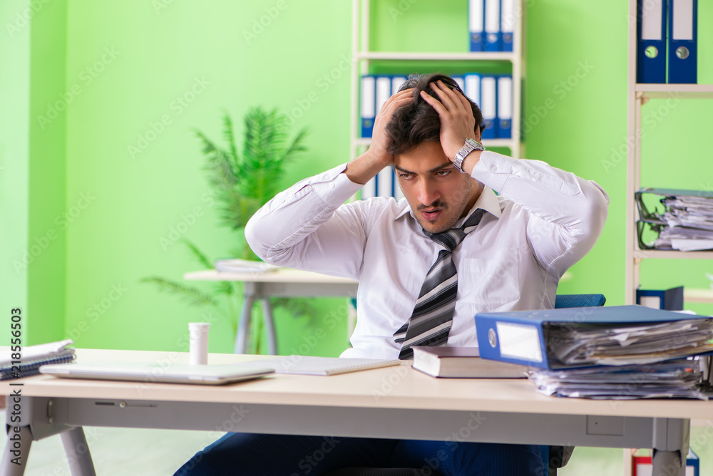 Sick and unhappy businessman sitting in the office Sick and unhappy businessman sitting in the office