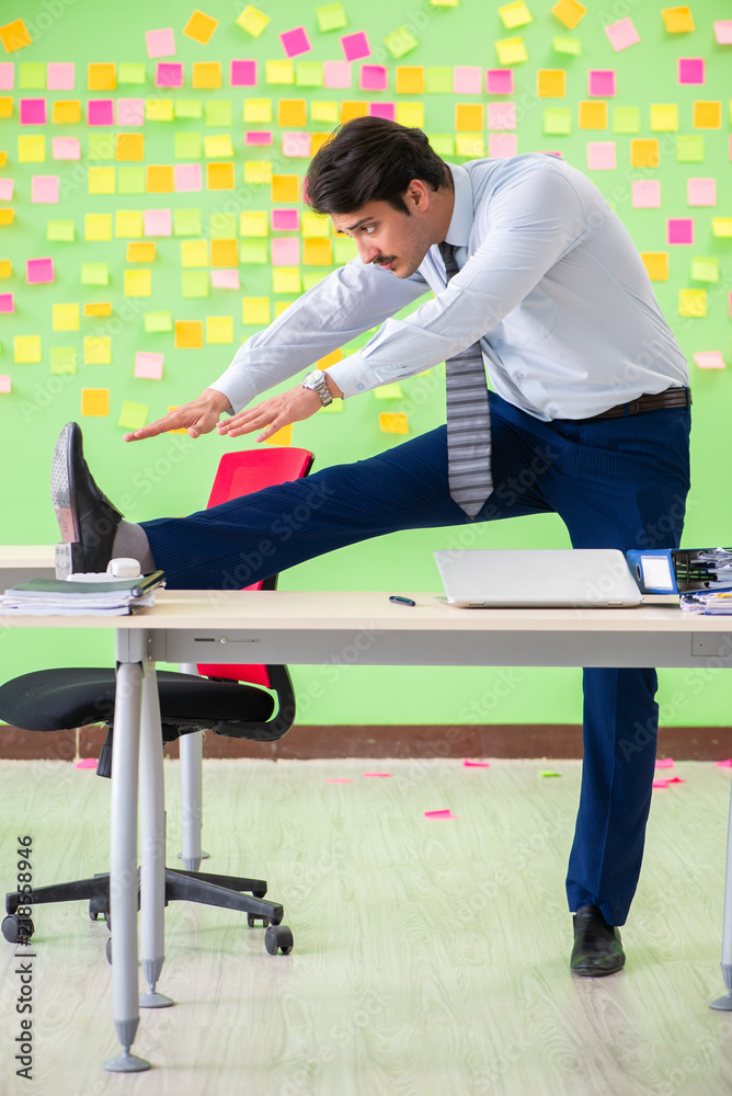 Man in the office with many conflicting priorities doing exercis