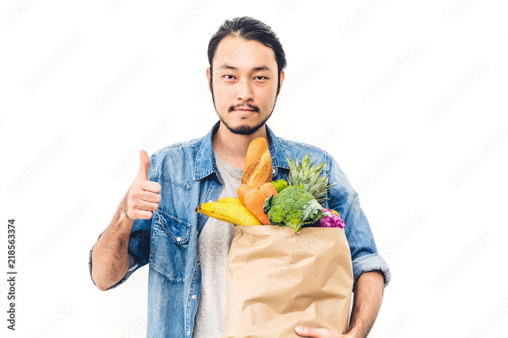Man holding shopping paper bag with fruit and vegetables on white background Man holding shopping paper bag with fruit and vegetables on white background