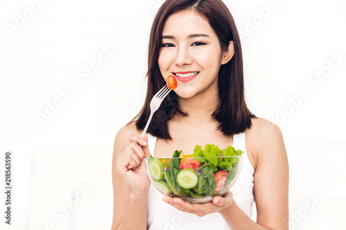 Happy woman eating and showing healthy fresh salad in a bowl.dieting concept.healthy lifestyle with green food