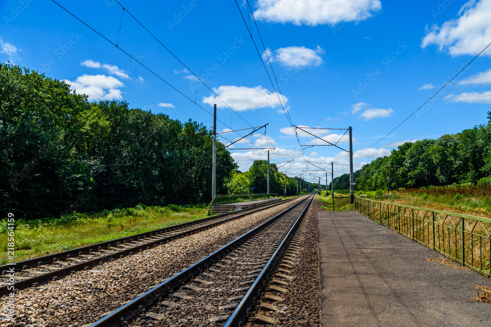 View on a railroad track and white clouds in blue sky