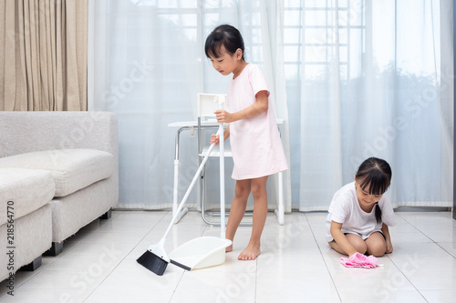 Asian Chinese little sisters helping doing cleaning