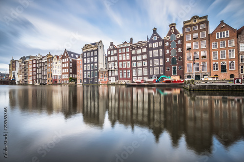Evening view of the "Dancing Houses of Damrak' , iconic canal houses in the capital city of Amsterdam.