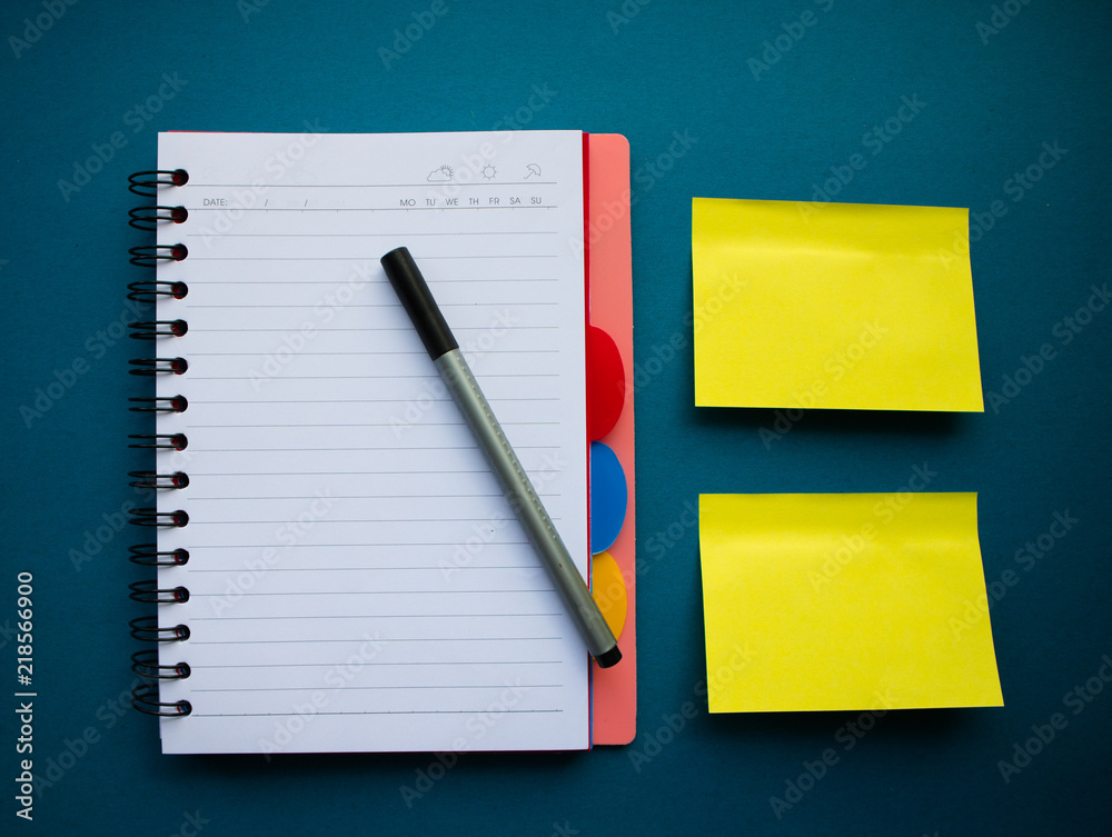 Сolorful blank sticky note or empty post notes with office clamps and notebook on blue background Сolorful blank sticky note or empty post notes with office clamps and notebook on blue background