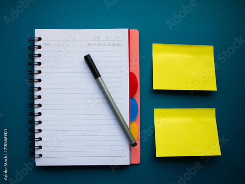 Сolorful blank sticky note or empty post notes with office clamps and notebook on blue background
