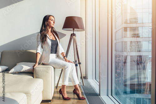 Woman sitting on a sofa at modern apartment