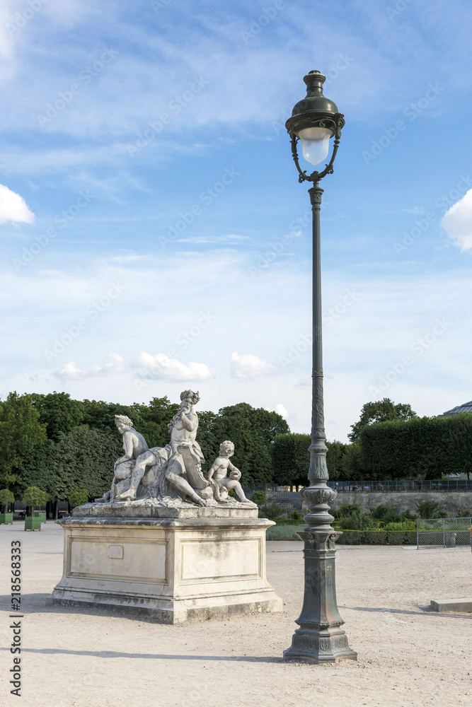 Paris, France - July 04, 2018: Sculptural composition and lamppost in the Tuileries Garden in Paris