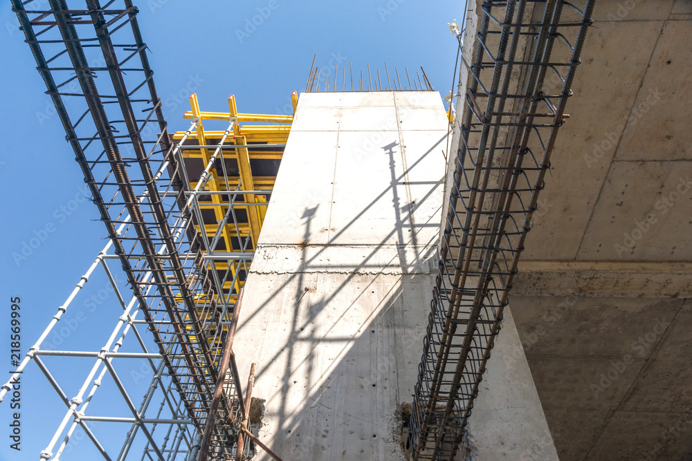 metal concrete structures of the building under construction. scaffolding and supports on a sky background. bottom view metal concrete structures of the building under construction. scaffolding and supports on a sky background. bottom view