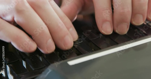 An extreme close shot of a stenographer or court reporter recording information via shorthand using a steno writer or stenograph. photo