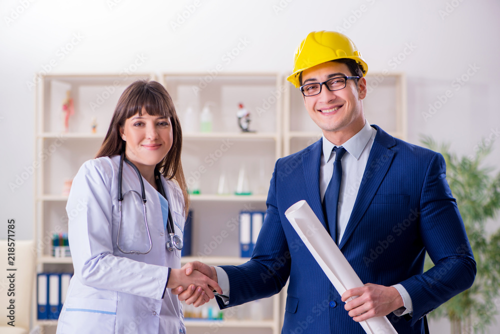 Doctor discussing new hospital plan with architect Doctor discussing new hospital plan with architect