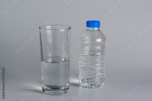 Glass and bottle with half water..