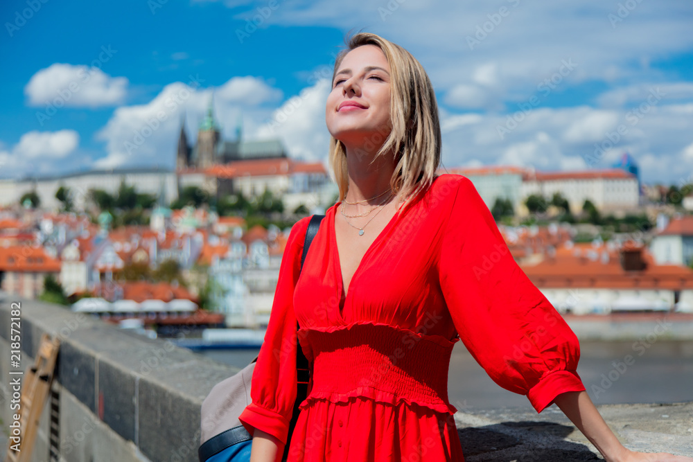 Beautiful girl in red dress travel in Prague, city streets