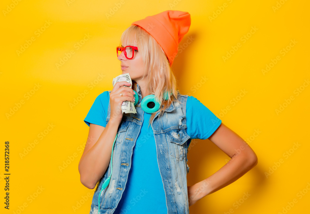 portrait of young trendy girl orange hat with money on yellow background portrait of young trendy girl orange hat with money on yellow background