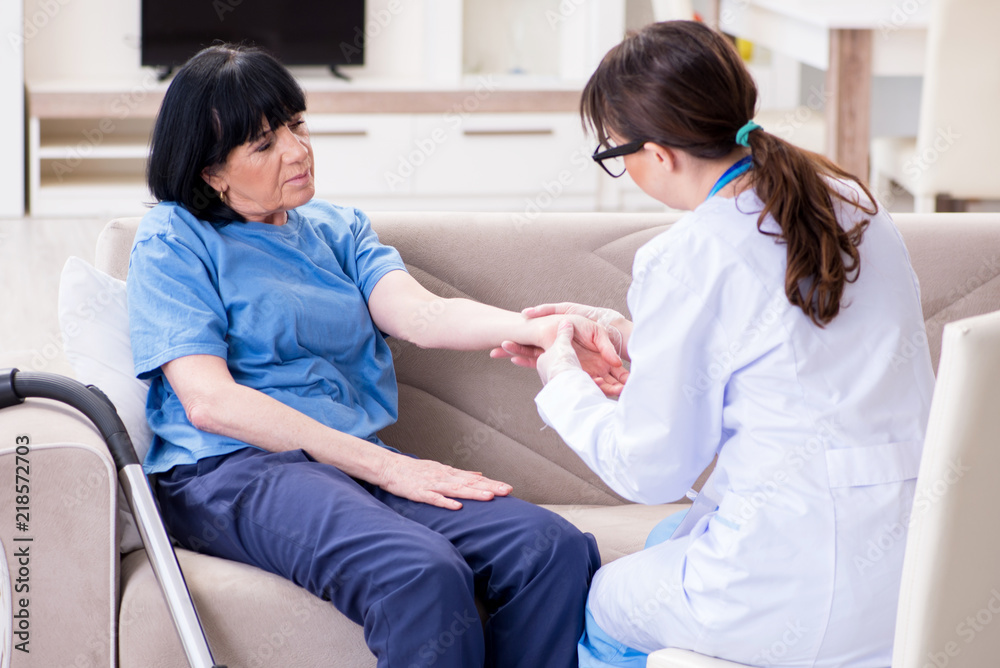 Obraz premium Young doctor visiting old mature woman for check-up