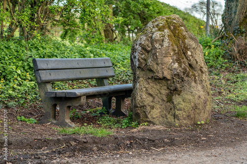 A bench with a large stone in front of it, seen between Church Stretton and Hope Bowdler, Shropshire, England, UK photo