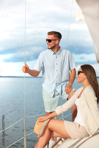 Attractive couple on a yacht enjoy bright sunny day on vacation. © ty