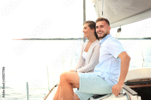 Attractive couple on a yacht enjoy bright sunny day on vacation. © ty