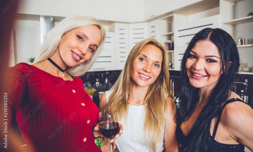 Three woman friends having fun in the kitchen and preparing food Three woman friends having fun in the kitchen and preparing food