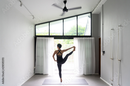 Asian young woman practicing yoga in gray background.Young people do yoga indoor.