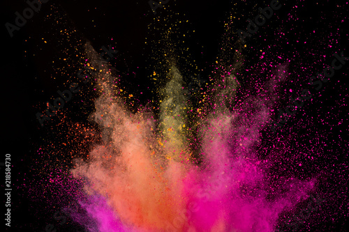 Explosion of coloured powder isolated on black background.