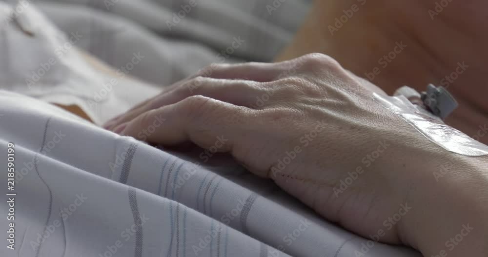 The patient in the hospital has a central puncture (catheter). The woman lies on the hospital bed. She moves her bandaged hand. Panning camera, Pan, Closeup The patient in the hospital has a central puncture (catheter). The woman lies on the hospital bed. She moves her bandaged hand. Panning camera, Pan, Closeup