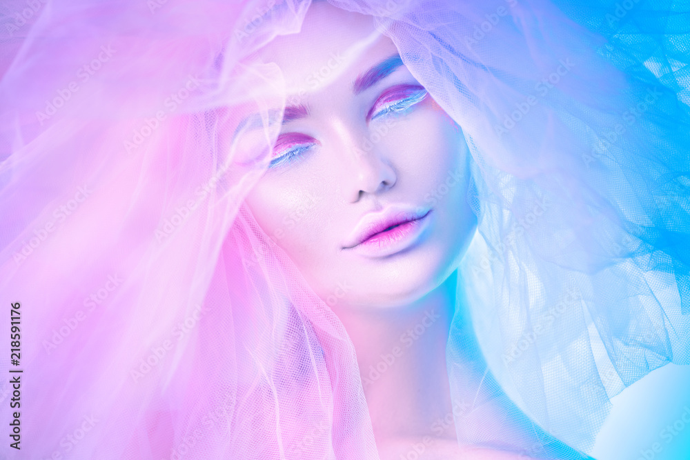 Fashion art portrait model woman in colorful bright neon lights posing, portrait of beautiful fantasy girl, trendy make-up and colourful tulle hairdo