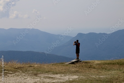 man taking picture mountain landscape