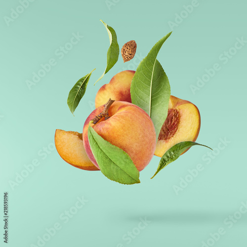 Obraz na płótnie Flying fresh ripe peach with green leaves isolated
