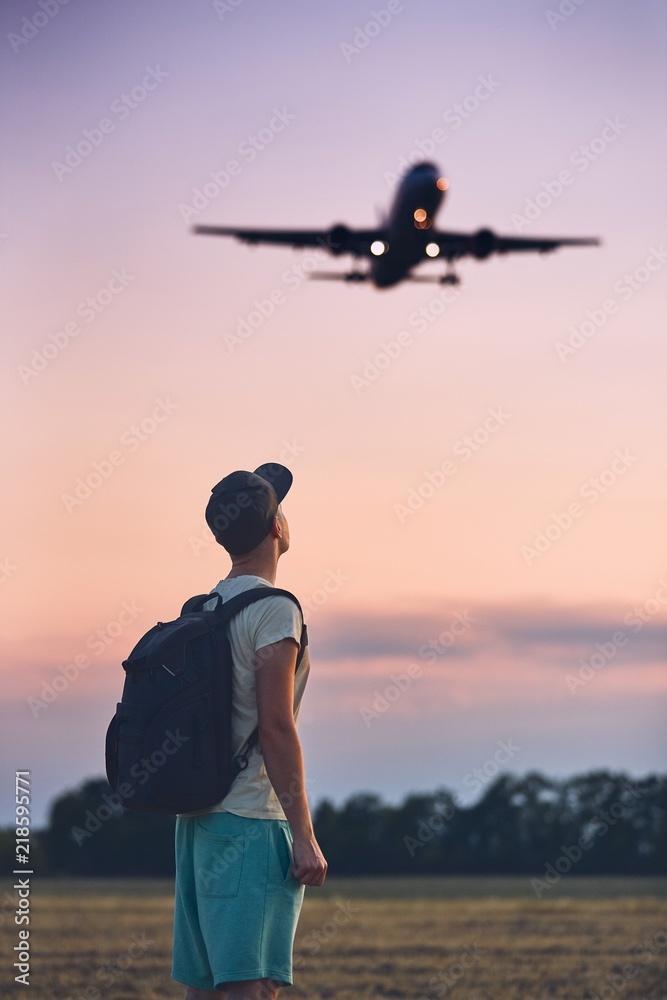 Naklejka premium Traveler is looking at the landing airplane