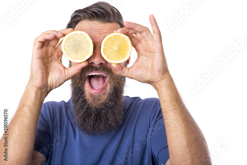 Happy bearded hipster man with sliced lemon on eyes