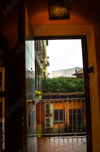 A rainy city view from inside of a house through the door