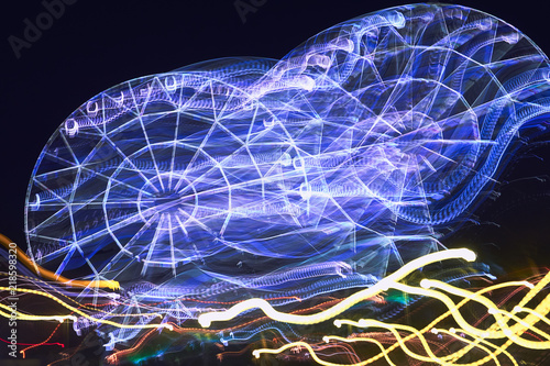 Lubricated when moving the camera on a long exposure illuminated by bright colors, the Ferris wheel in the park creates different varints of lines of light and colors for the background and patterns